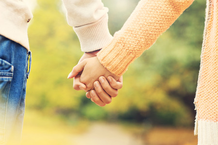 47199086 – a picture of a couple holding hands in the park