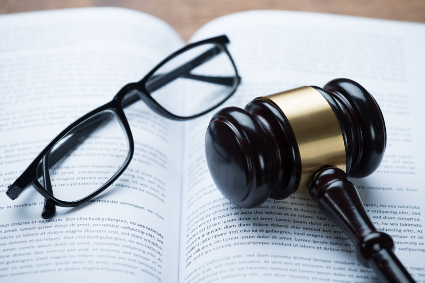 Mallet And Eyeglasses On Open Legal Book